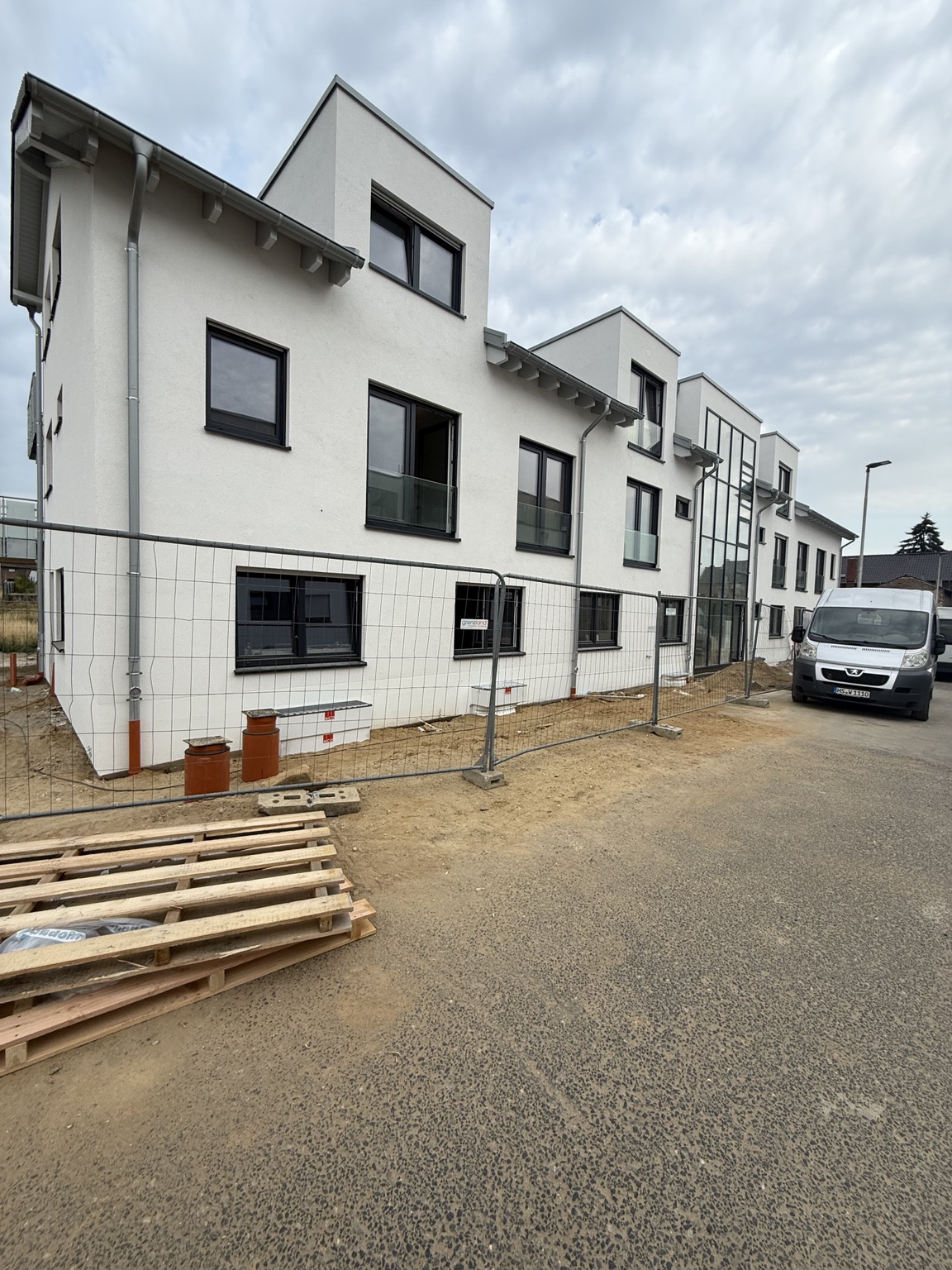 Mehrfamilienkomplex mit zehn Wohneinheiten und hoher Glasfassade während der Bauphase